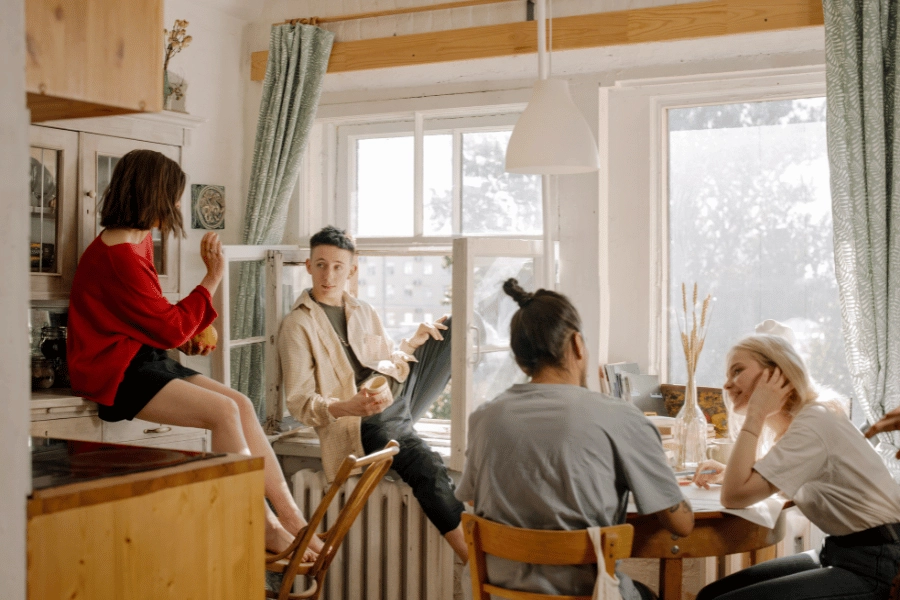 co-living residents in the kitchen talking and drinking coffee